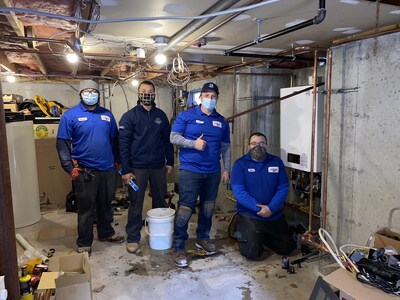 Picture of Al and team of highly-skilled HVAC technicians installing a free heating system for homeowner in need.