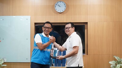 General Manager of PLN UID Jakarta Raya, Moch. Andy Adchaminoerdin, handed over a miniature of the Public Electric Vehicle Charging Station to the President Director of BDx Indonesia, Agus Hartono Wijaya