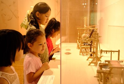 Kazakh children observing weaving loom models, Photo by Chen Shangwen, from People's Daily