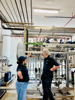 Esben Niewald, SPX FLOW Innovation Center Engineer, and Cindy Thys, SIG MEA Technical Center Manager, point out the newly extended APV UHT line at the Dubai Customer Experience Hub.