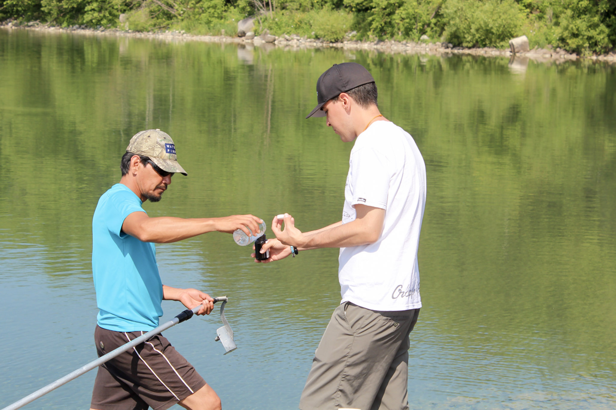 Chris Wemigwans (left) collects water samples with another graduate during the inaugural Drinking Water Internship Program on Manitoulin Island