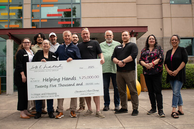 Smiling for the camera, Jeff Swickard, Swickard Auto Group team, and the Helping Hands Reentry Outreach Centers team stand outside Bybee Lakes Hope Center, holding a large check made out to "Helping Hands" for $25,000 from the Swickard Auto Group.