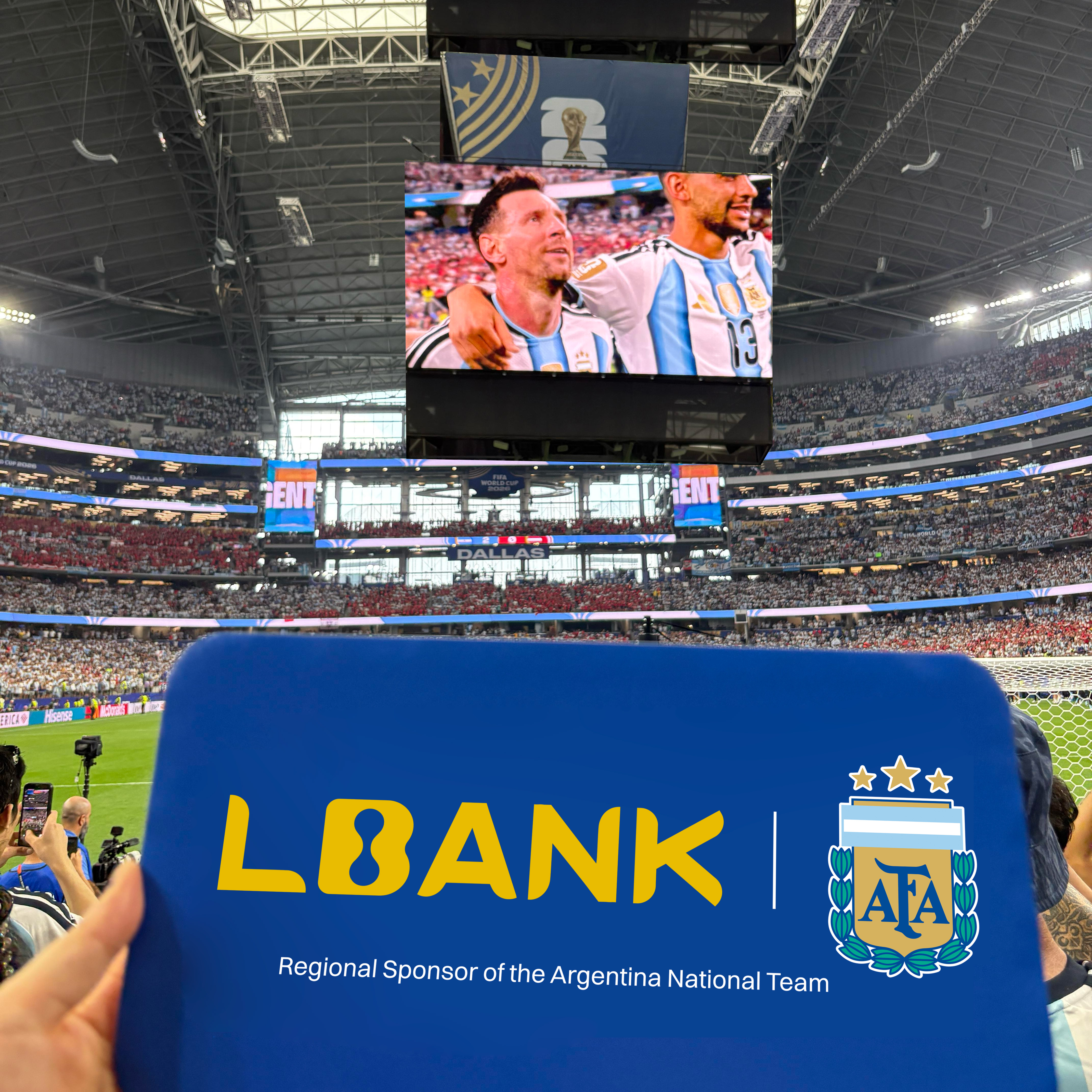 A hand holding a blue LBank pad that says 'AFA Regional Sponsor' inside AT&T Stadium.