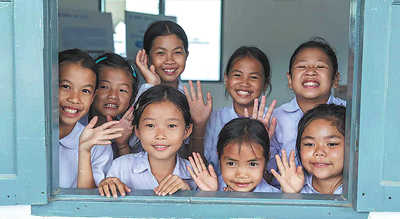 Children peer through a window of a small library built by China International Water & Electric Corp in Thinsom village, Luang Prabang province, Laos. CHINA DAILY