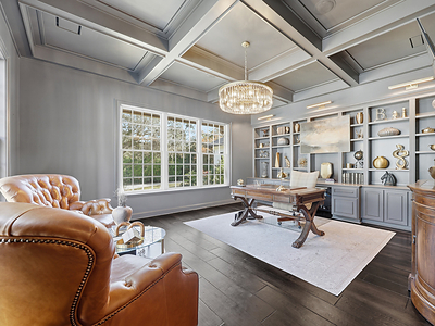 The handsome study features lofted ceilings with custom tray work, extensive built-ins and oversized windows with views of the grounds. FLLuxuryAuction.com.