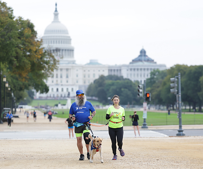 Thomas Panek, Lighthouse Guild President & CEO, running with Kelly Ingham, Vice President of AI Wearables and Research Partnerships, and Achilles guide Adam Foutz