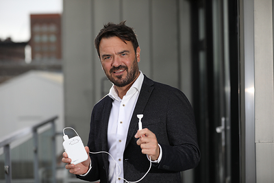 Neuromod Founder and CEO, Dr. Ross O’Neill Ph. D. holding the Lenire bimodal neuromodulation tinnitus treatment device.