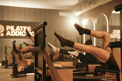 Pilates Addiction patented Aurum™ Reformer, paired with a striking black-and-gold studio design. 