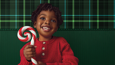 A young boy celebrates the season in a festive red sweater with a candy cane.